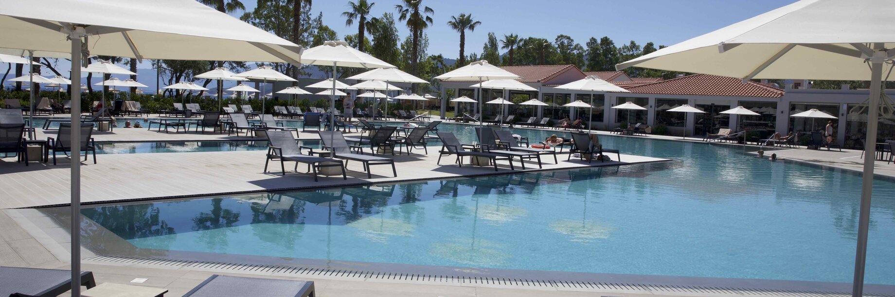 a pool with lounge chairs around it