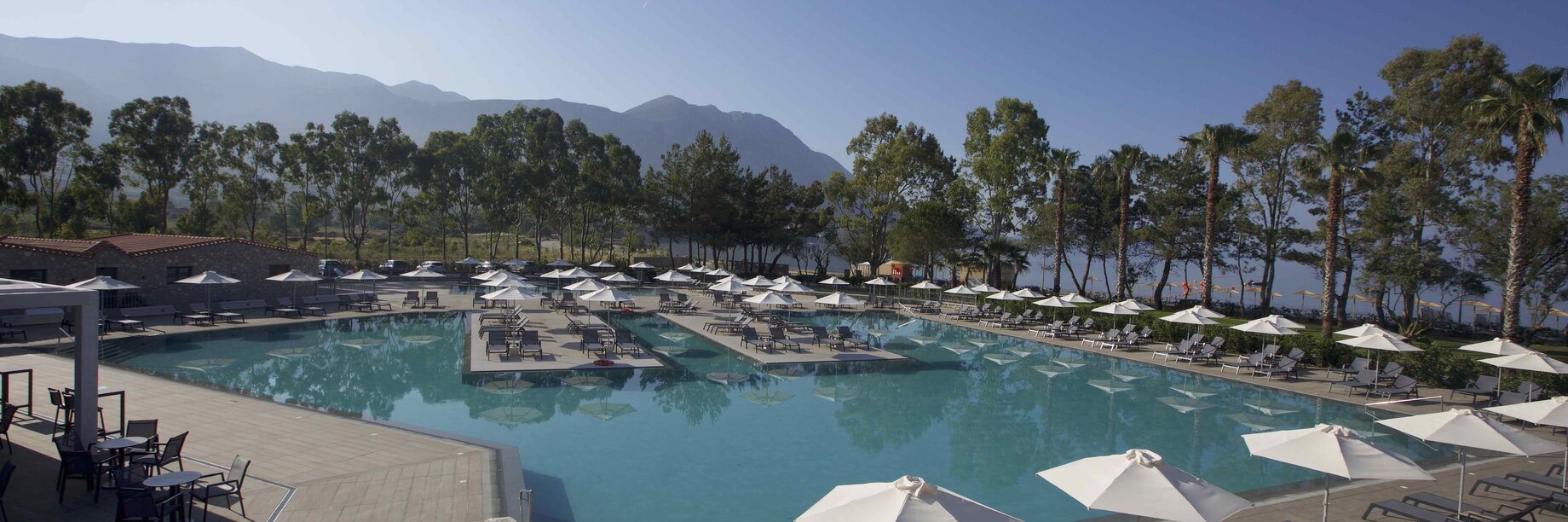 a pool with chairs and umbrellas by it