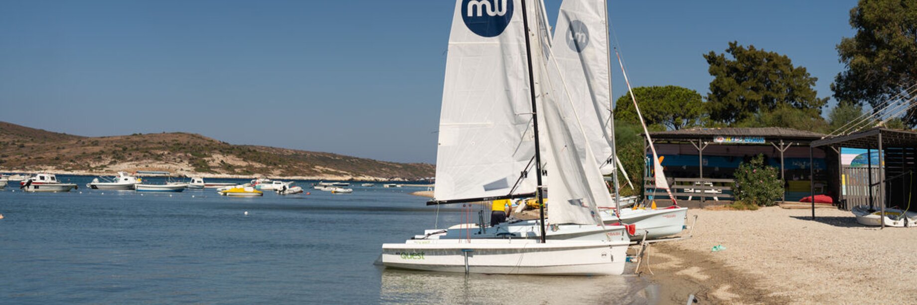 Waterfront with two dinghy sailing boats at Phokaia Beach Resort, Turkey