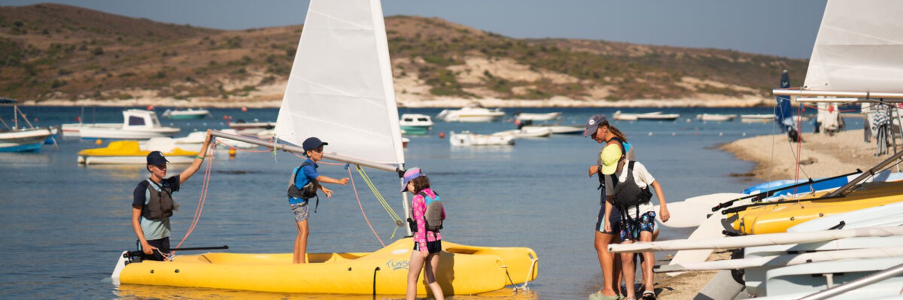 Children getting onto a dinghy sailing boat at Phokaia Beach Resort
