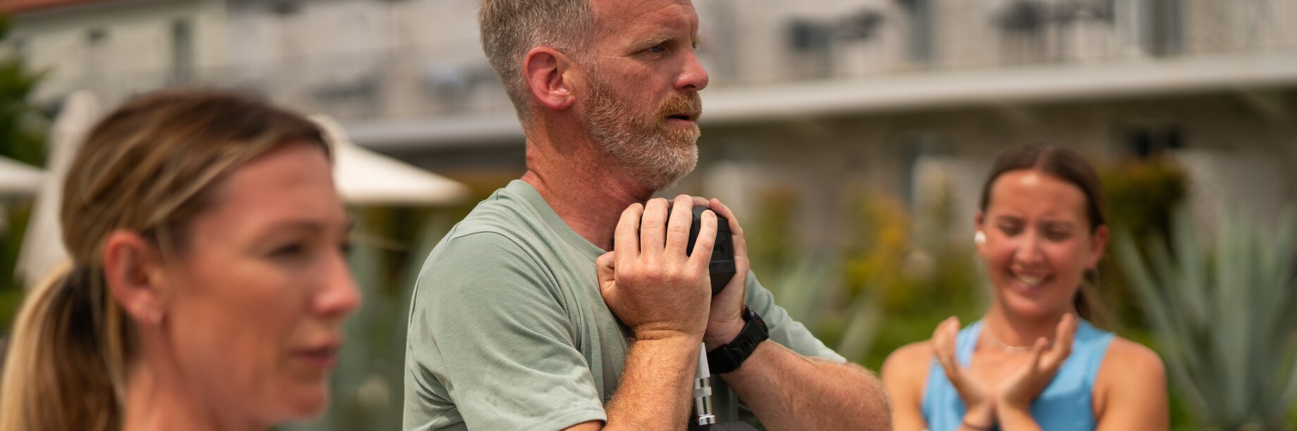 two people in a fitness class doing weighted squats near the adult pool at Paleros Beach resort