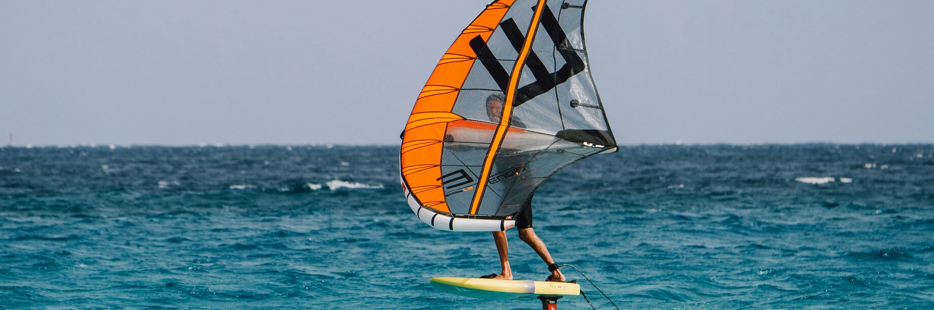 a person wingfoiling on turquoise seas