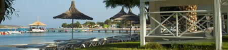a deck with chairs and umbrellas by a body of water