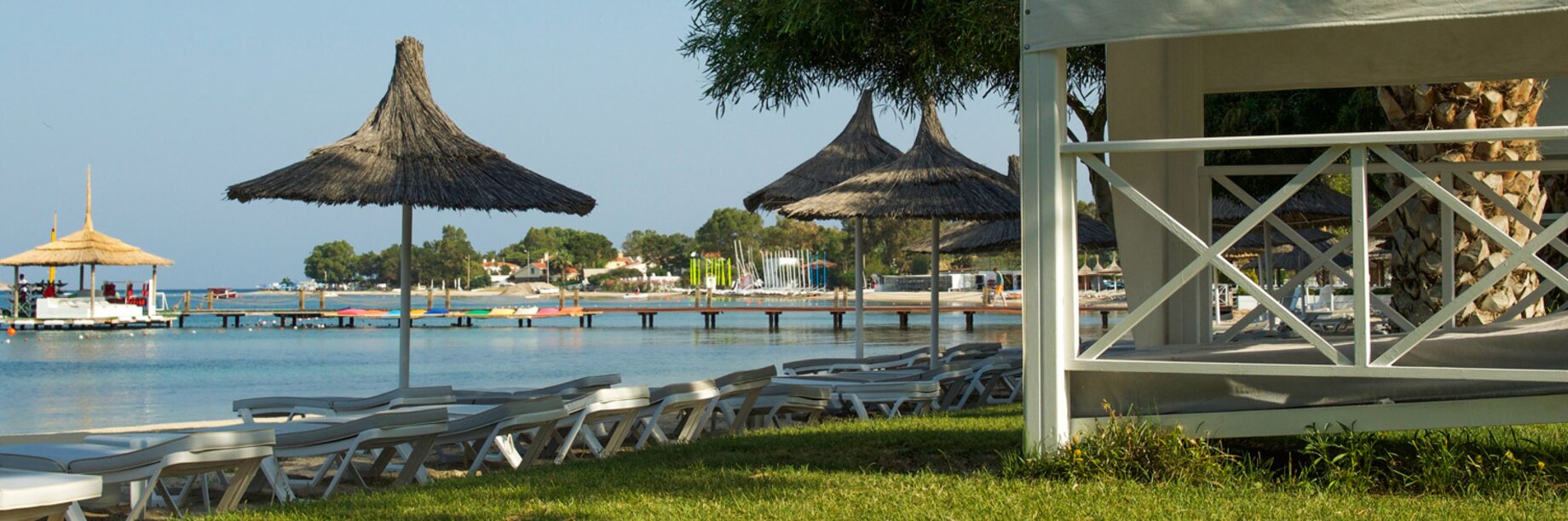 a deck with chairs and umbrellas by a body of water