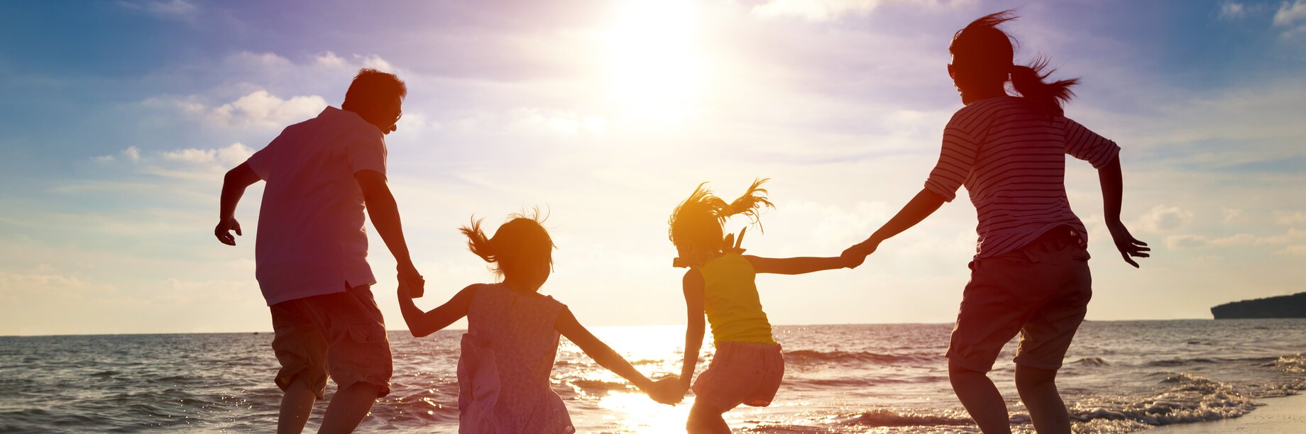 a family running on the beach
