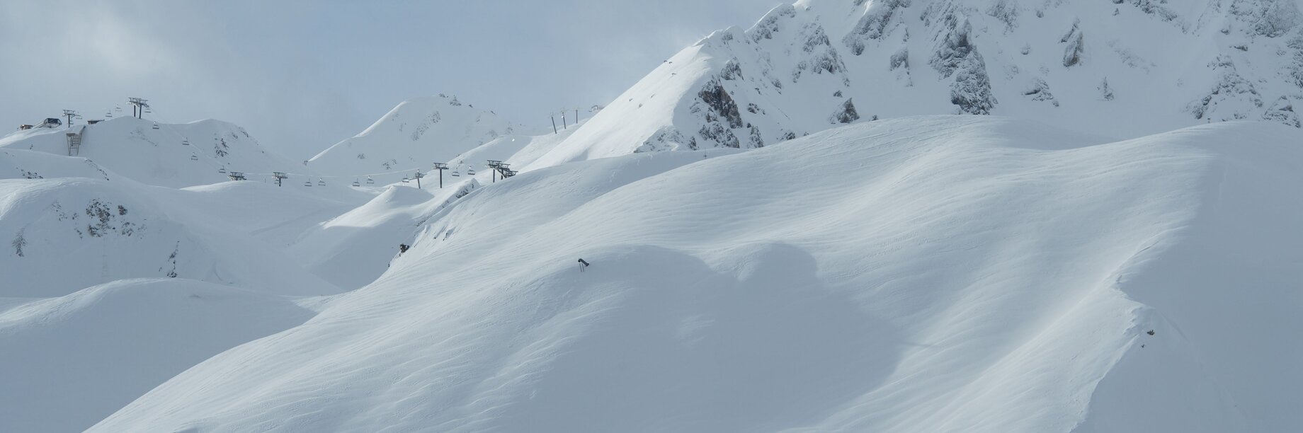 a snowy mountain with a few people on it