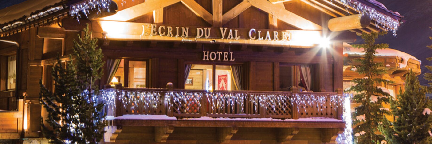 a building with a deck and trees in front of it