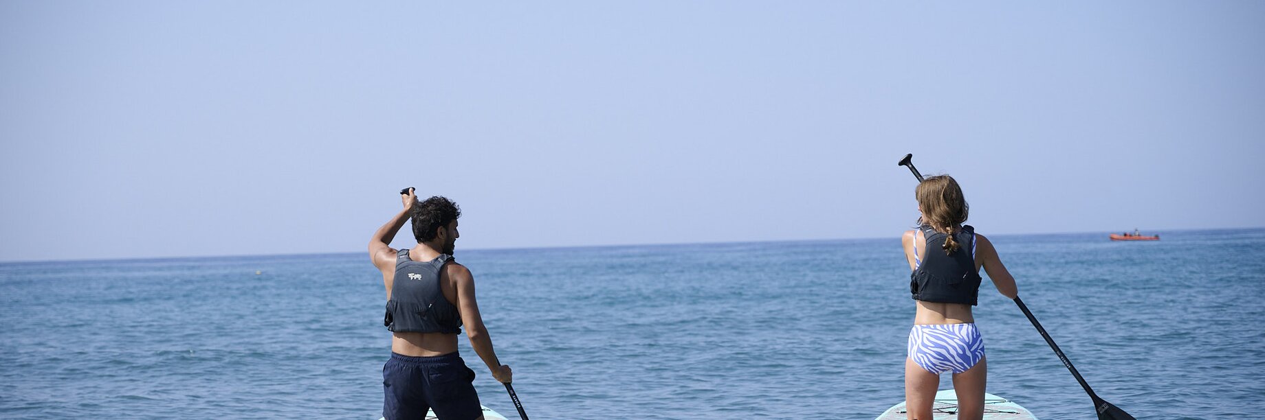 Two people paddle boarding on an active Mark Warner holiday